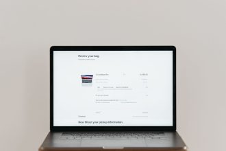 Laptop exibindo uma tela de checkout de compras online sobre fundo branco.