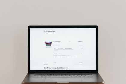 Laptop exibindo uma tela de checkout de compras online sobre fundo branco.