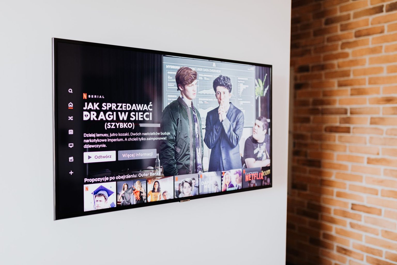Smart TV exibindo conteúdo de streaming em uma sala de estar moderna com parede de tijolos aparentes