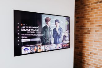 Smart TV exibindo conteúdo de streaming em uma sala de estar moderna com parede de tijolos aparentes