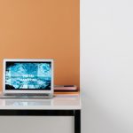 Laptop em uma estação de trabalho moderna exibindo conteúdo relacionado a marketing digital.