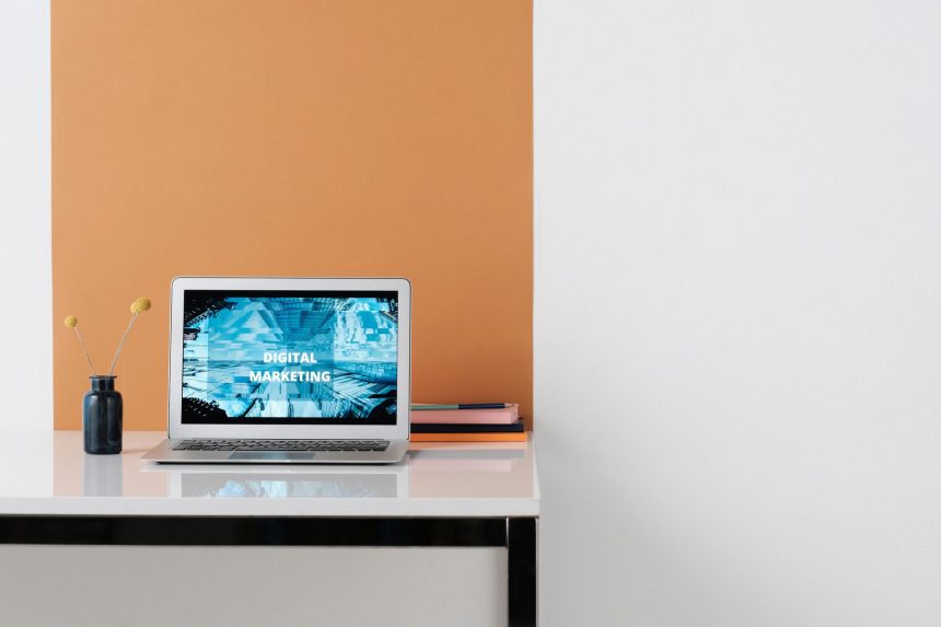 Laptop em uma estação de trabalho moderna exibindo conteúdo relacionado a marketing digital.
