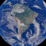 Ilustração digital de um satélite observando a Terra, com a América do Sul em destaque sobre oceanos azuis.