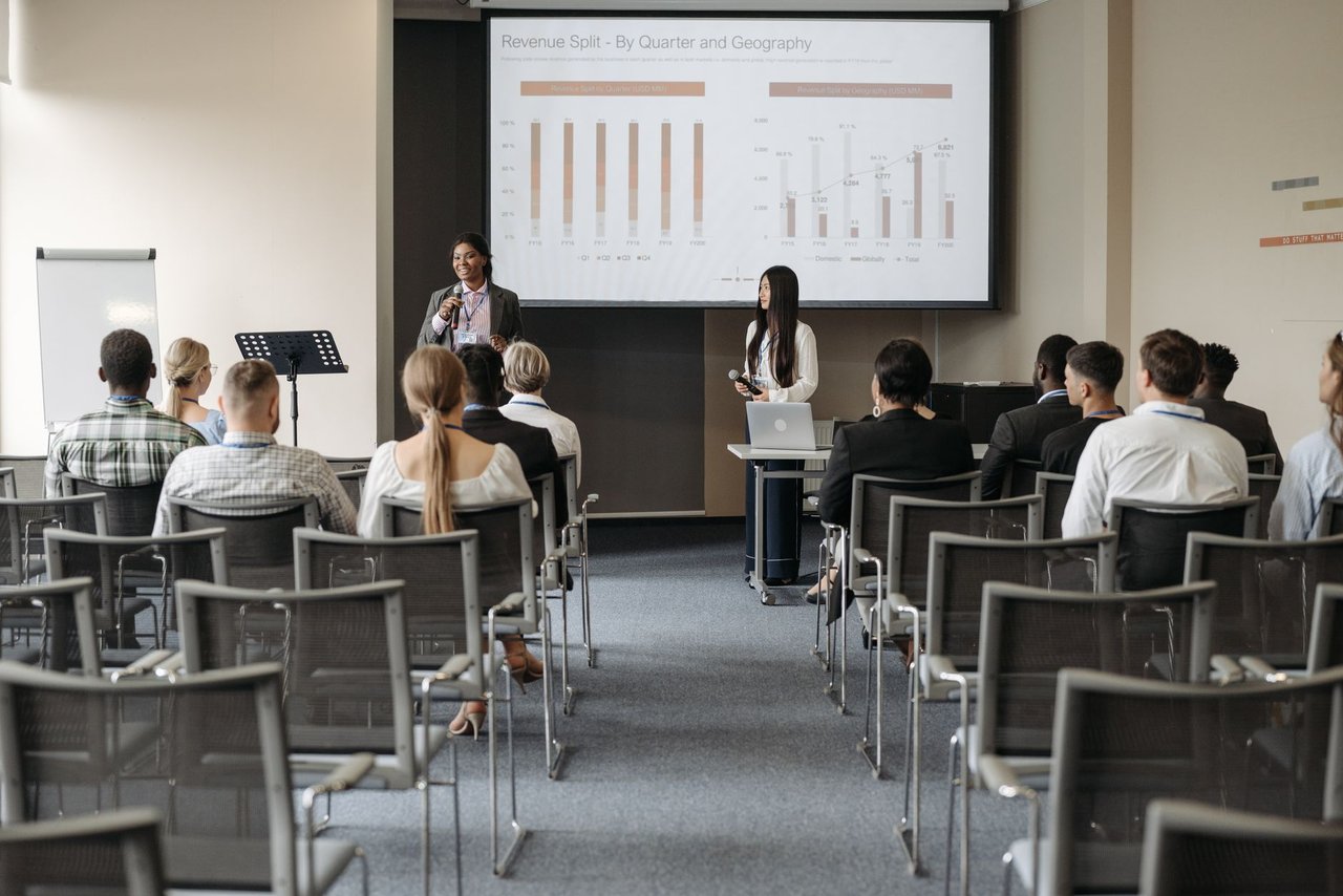 Participantes acompanham uma apresentação em um seminário empresarial sobre dados e negócios.